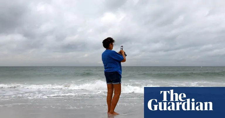  seashore, coast, seacoast, sea-coast sandbar, sand bar cellular telephone, cellular phone, cellphone, cell, mobile phone swimming trunks, bathing trunks-0